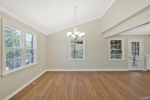 spare room featuring lofted ceiling, ornamental molding, hardwood / wood-style floors, and a notable chandelier