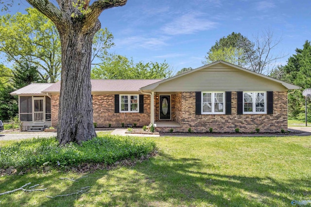 single story home with a front lawn and a sunroom