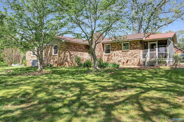 rear view of property featuring a yard and a sunroom