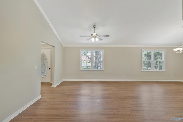 unfurnished room with crown molding, ceiling fan with notable chandelier, and light wood-type flooring