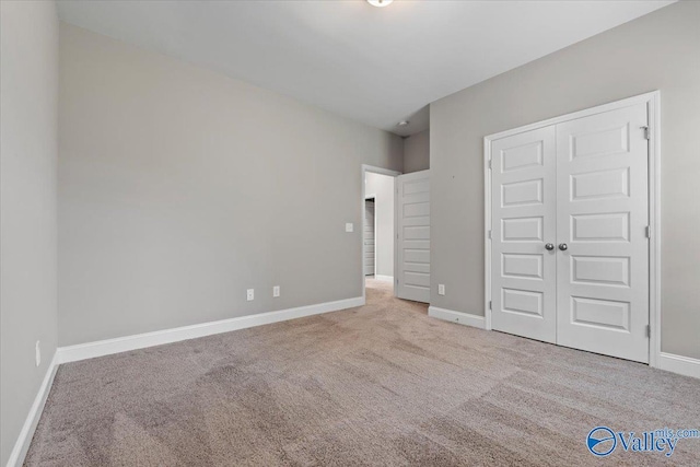 unfurnished bedroom featuring carpet, baseboards, and a closet