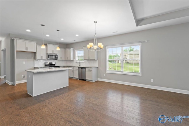 kitchen featuring stainless steel appliances, dark wood finished floors, baseboards, backsplash, and recessed lighting