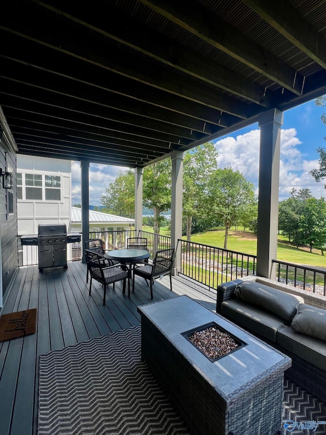 wooden terrace featuring grilling area and an outdoor fire pit