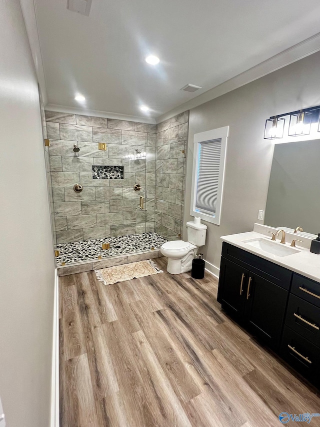 bathroom featuring vanity, walk in shower, crown molding, hardwood / wood-style floors, and toilet