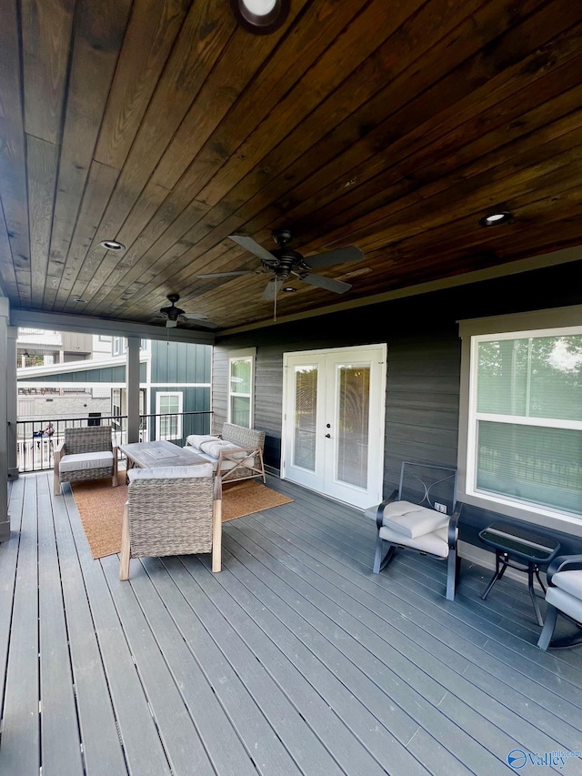 wooden terrace with an outdoor hangout area, french doors, and ceiling fan