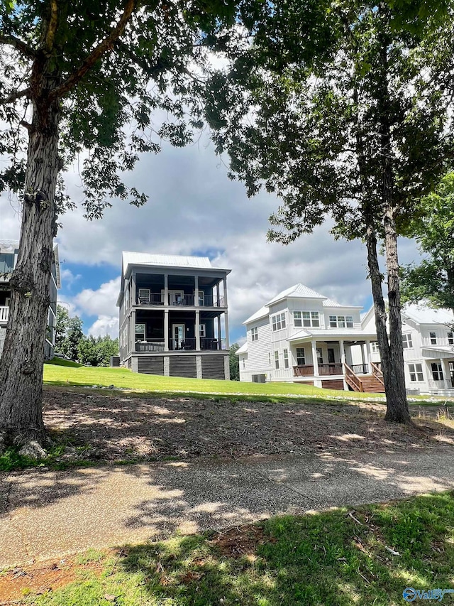 rear view of property featuring a porch and a yard