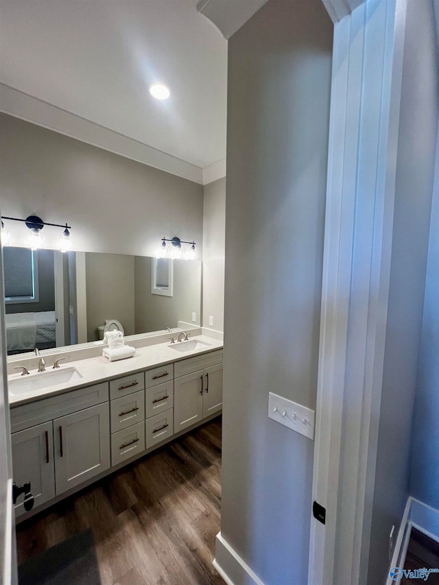 bathroom featuring dual vanity, hardwood / wood-style floors, and ornamental molding