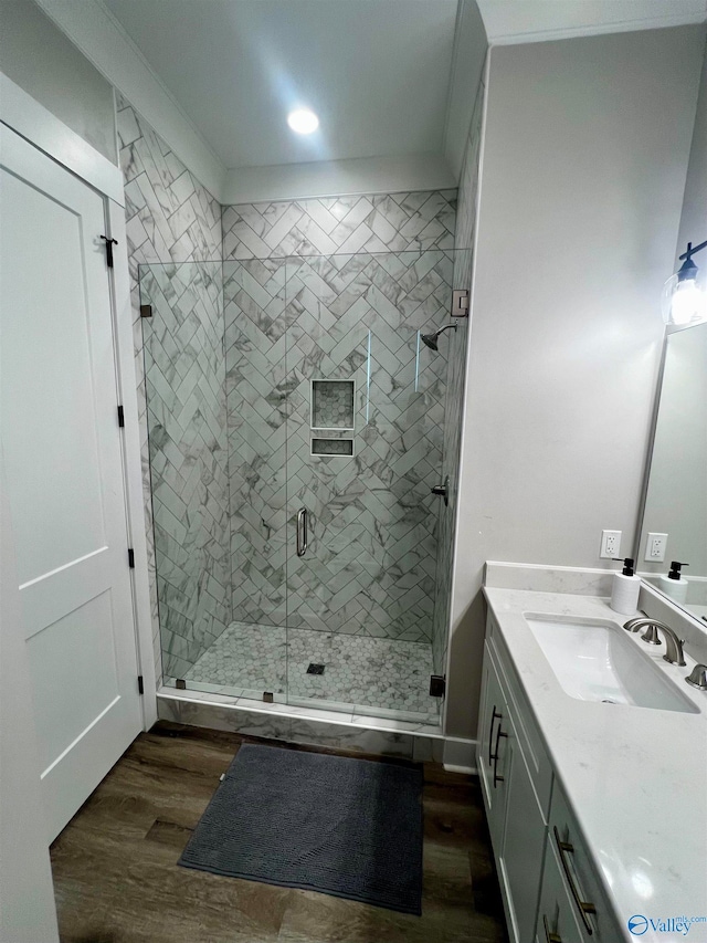 bathroom with vanity, walk in shower, and hardwood / wood-style floors