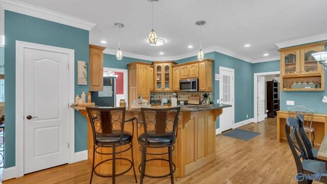 44 Jeff St, Scottsboro, AL 35769 - kitchen featuring stainless steel microwave, a breakfast bar, glass insert cabinets, recessed lighting, and tasteful backsplash