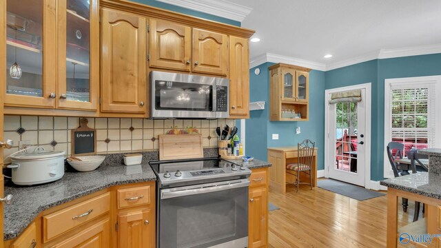 44 Jeff St, Scottsboro, AL 35769 - kitchen with stainless steel appliances, crown molding, light wood finished floors, tasteful backsplash, and dark stone countertops