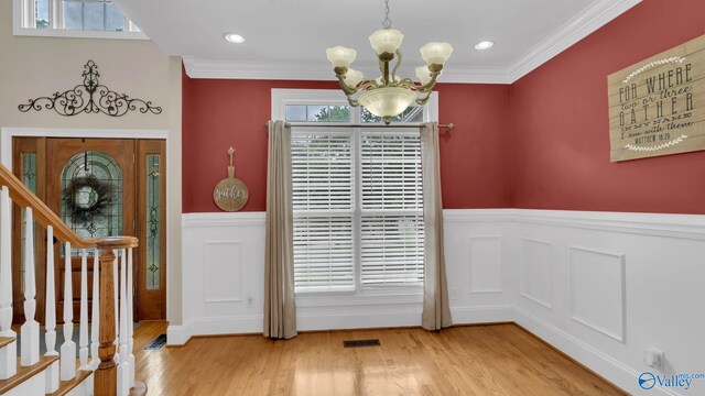 44 Jeff St, Scottsboro, AL 35769 - entryway with a chandelier, wainscoting, wood finished floors, stairway, and ornamental molding