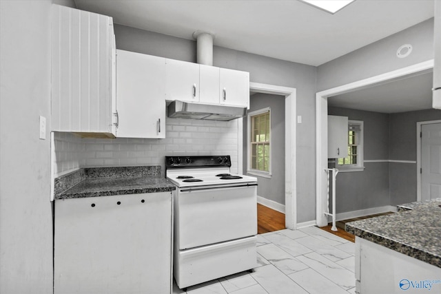 1617 7th St SE, Decatur, AL 35601 - kitchen with electric stove, under cabinet range hood, white cabinetry, decorative backsplash, and dark countertops