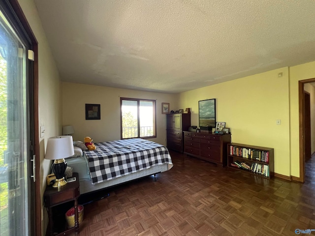 bedroom with a textured ceiling, access to exterior, and parquet floors