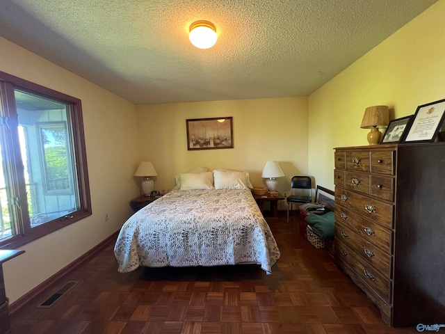 bedroom featuring a textured ceiling and dark parquet floors