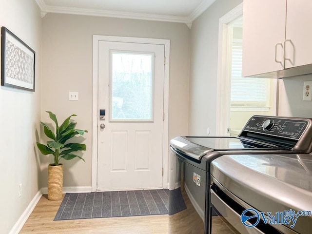 laundry area with crown molding, cabinet space, separate washer and dryer, wood finished floors, and baseboards