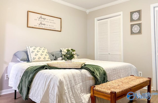 bedroom with baseboards, ornamental molding, a closet, and wood finished floors