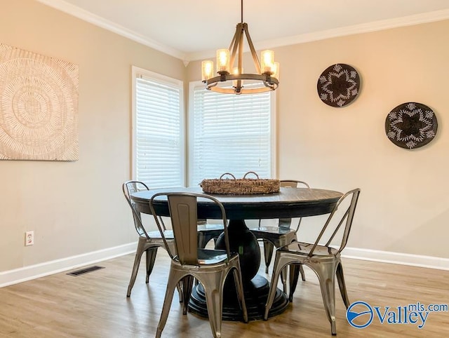 dining area with a chandelier, ornamental molding, visible vents, and baseboards