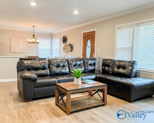 living area featuring light wood-style floors, plenty of natural light, an inviting chandelier, and crown molding