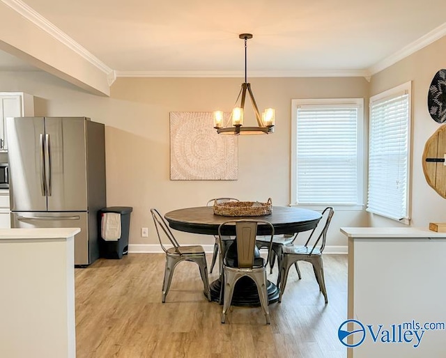 dining room featuring an inviting chandelier, light wood-style flooring, baseboards, and crown molding