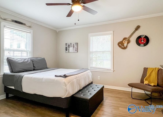 bedroom with light wood-style floors, crown molding, baseboards, and a ceiling fan