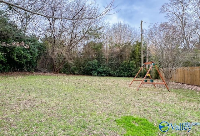 view of yard featuring a playground and fence