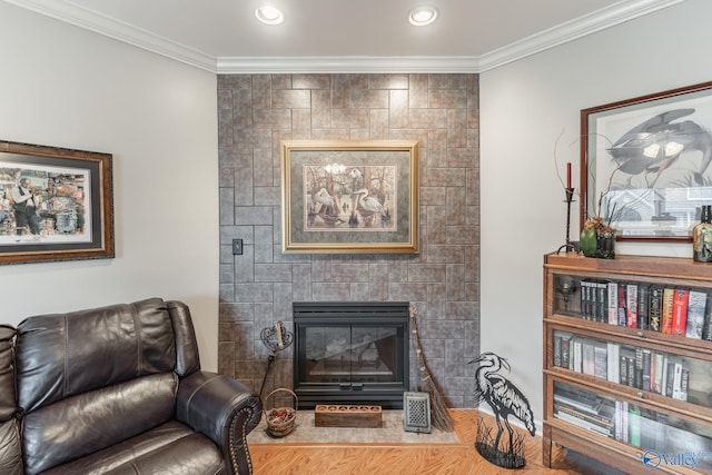 living area featuring a tile fireplace and ornamental molding