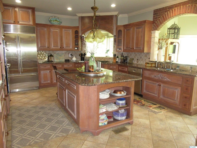 kitchen with sink, a kitchen island, appliances with stainless steel finishes, and backsplash