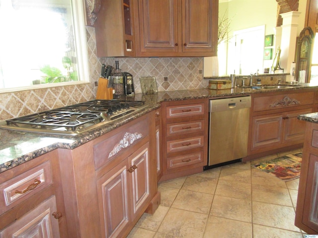 kitchen featuring light tile patterned floors, a wealth of natural light, decorative backsplash, and stainless steel appliances