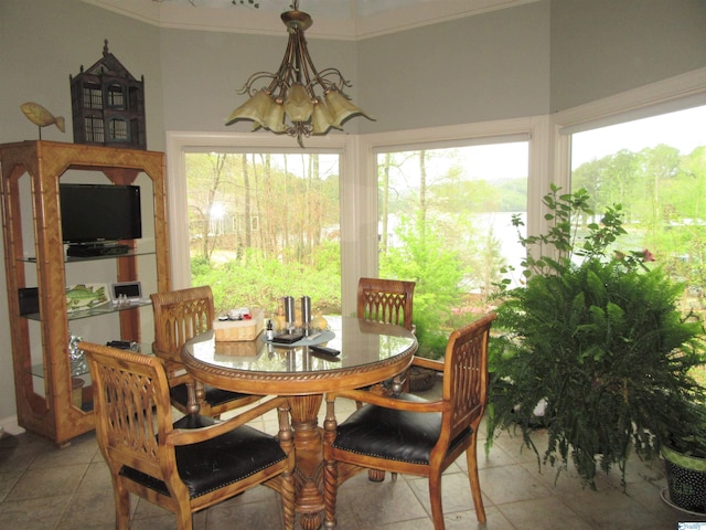 tiled dining room with an inviting chandelier and crown molding