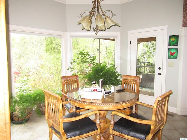 dining space featuring tile patterned floors, crown molding, and a notable chandelier