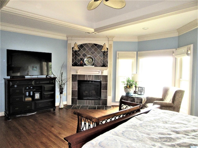 bedroom featuring a tile fireplace, wood-type flooring, and crown molding