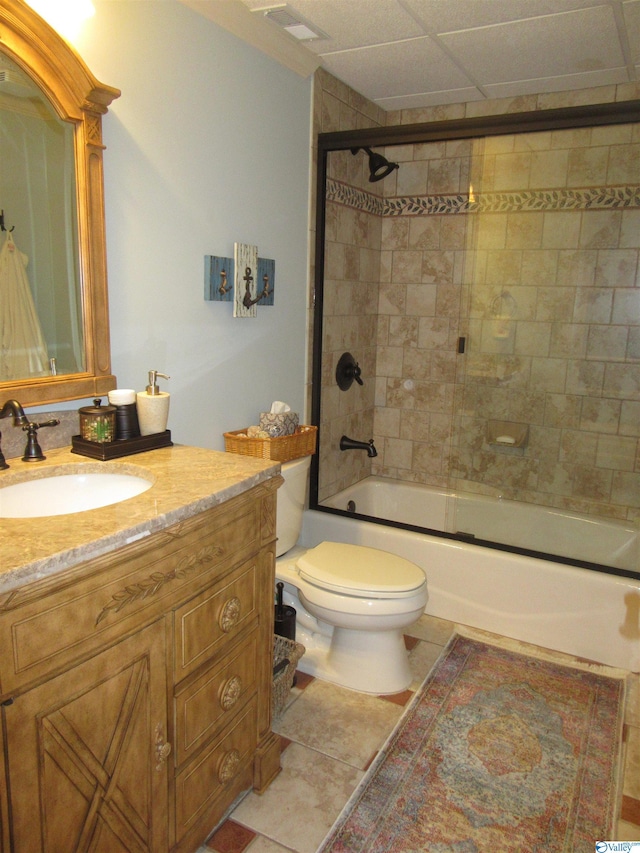 full bathroom with a paneled ceiling, enclosed tub / shower combo, tile patterned flooring, toilet, and vanity