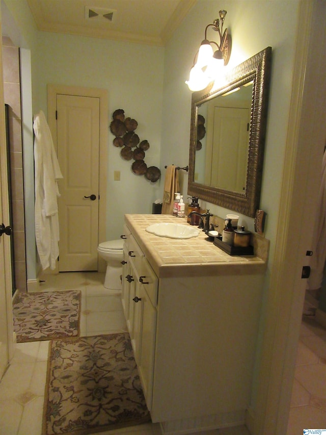 bathroom featuring tile patterned floors, toilet, vanity, and ornamental molding