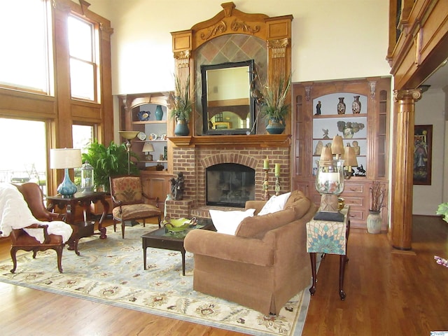 living room featuring a fireplace, hardwood / wood-style flooring, and a high ceiling