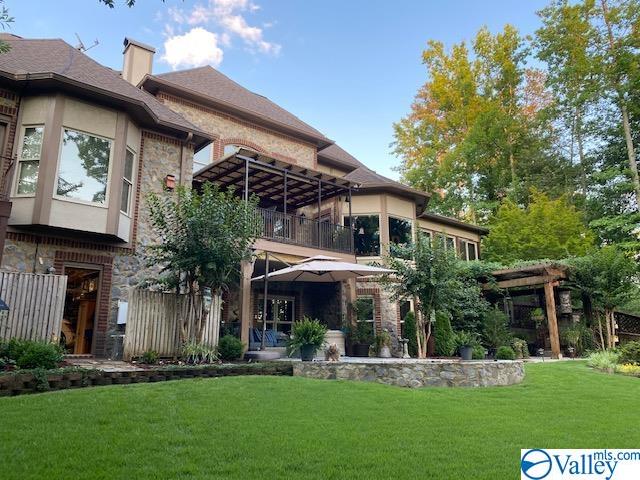 rear view of property with a yard and a balcony