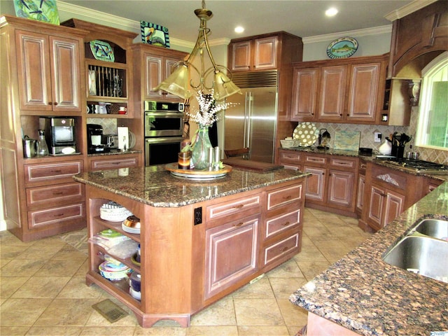 kitchen featuring a kitchen island, appliances with stainless steel finishes, decorative backsplash, and decorative light fixtures