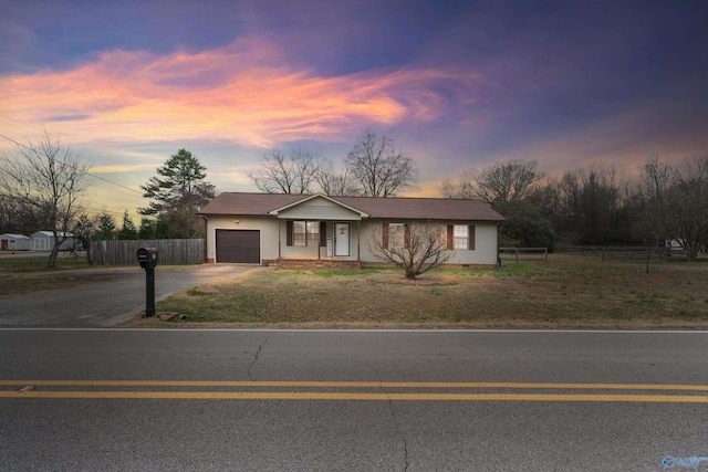 ranch-style home with a yard and a garage