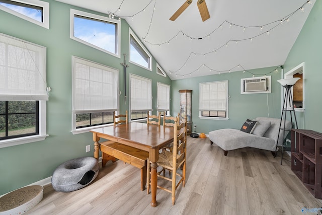 dining room with an AC wall unit, ceiling fan, high vaulted ceiling, and light hardwood / wood-style floors