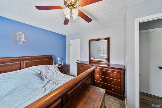 bedroom featuring a closet, a textured ceiling, dark hardwood / wood-style floors, and ceiling fan