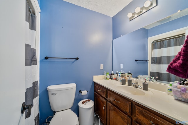 bathroom with vanity, a textured ceiling, and toilet