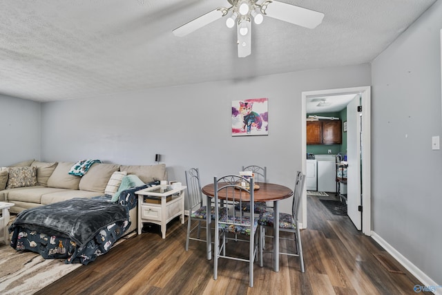 dining room with a textured ceiling, washing machine and dryer, dark hardwood / wood-style floors, and ceiling fan