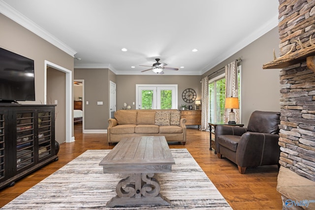 living room with hardwood / wood-style flooring, ornamental molding, and ceiling fan