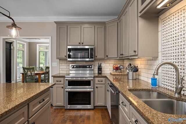 kitchen featuring stainless steel appliances, decorative backsplash, crown molding, sink, and dark wood-type flooring