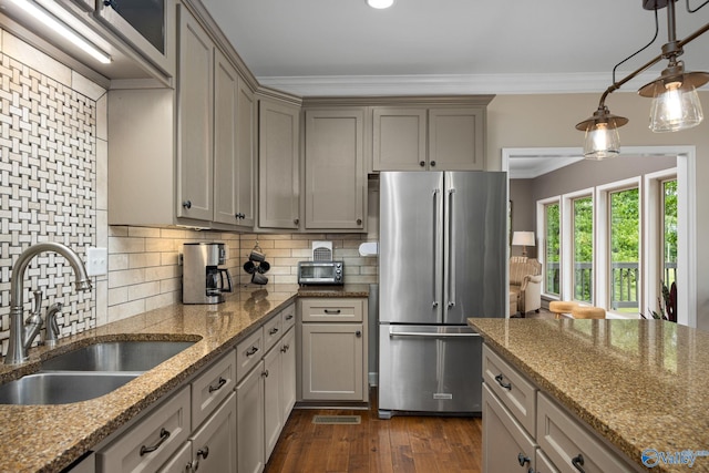 kitchen featuring tasteful backsplash, stainless steel refrigerator, dark hardwood / wood-style flooring, hanging light fixtures, and ornamental molding