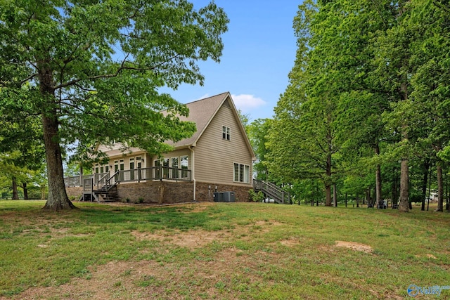 exterior space featuring a deck, central air condition unit, and a lawn