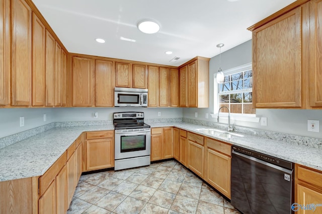 kitchen with light stone countertops, visible vents, a sink, stainless steel appliances, and pendant lighting