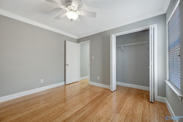 unfurnished bedroom with crown molding, ceiling fan, baseboards, light wood-style floors, and a closet