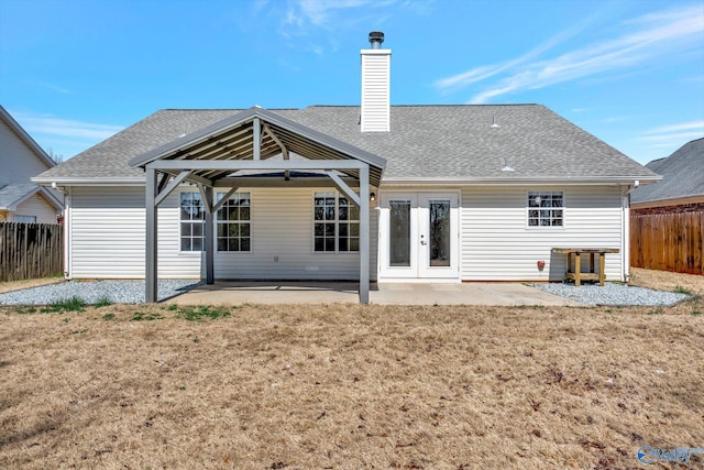 rear view of house featuring fence, a gazebo, french doors, a chimney, and a patio