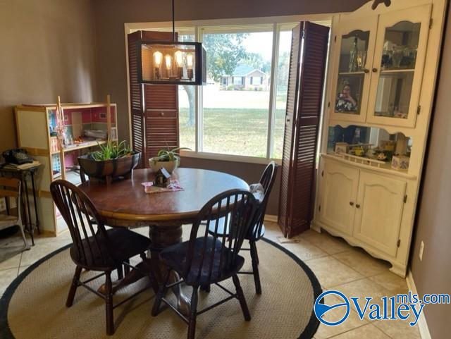 dining room featuring a notable chandelier, baseboards, and light tile patterned floors