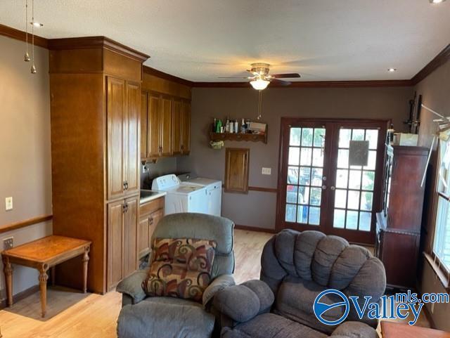 interior space featuring ornamental molding, light wood-type flooring, french doors, and separate washer and dryer